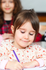 Happy little girl in school with her friends arround