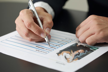 businessman's Hand holding a pen pointing to the Design title of
