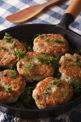 fishcakes with herbs close-up in a pan. vertical
