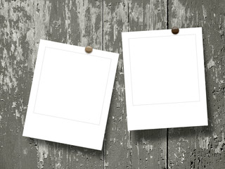 Double square empty photo frames with pins on dark brown wooden boards background