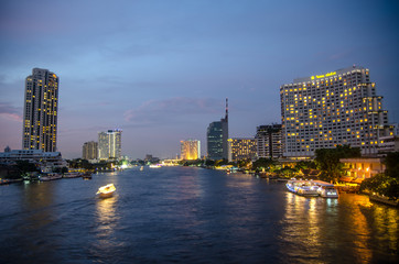 Fototapeta na wymiar Bangkok cityscape with river and boat at night time . Chao Phray