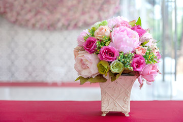 colorful artificial flowers made from cloth in a rectangular ceramic vase on a table