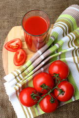 A glass of tomato juice and ripe tomatoes..