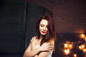 Obraz na płótnie Canvas The girl with red hair against the background lights