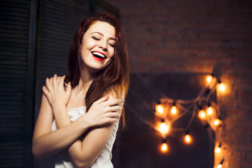 Obraz na płótnie Canvas The girl with red hair against the background lights