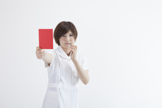 レッドカードを持つ看護師