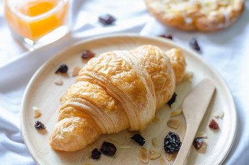 Croissant in wooden dish with blurred background