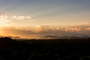Crepuscular sun rays during sunset over the hill