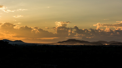 Crepuscular sun rays during sunset over the hill