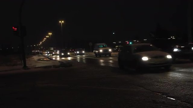 Trafico en autovia urbana, de noche y nevando
 - Paso de vehiculos en la noche y en ambos sentidos, en un cruce de  carretera de circunvalacion de doble carril urbana, mientras nieva en invierno 
