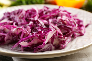 Red cabbage salad served on plate closeup