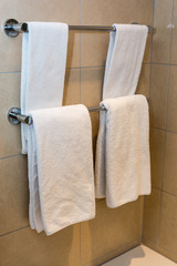 Bathroom Towels - white towels on a hanger prepared to use