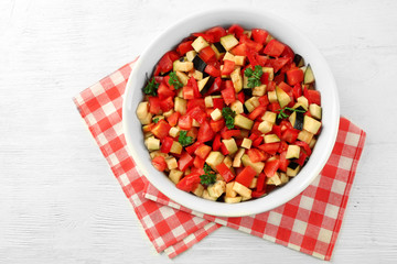 Ratatouille, stewed vegetable dish with tomatoes, zucchini, eggplant before cooking, on wooden background