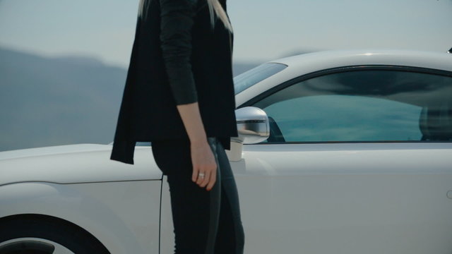 Stylish woman sits in a sports car