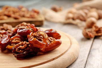 Walnut, date fruit on wooden table, close-up