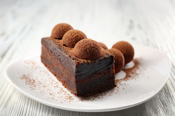 Slice of chocolate cake with a truffle on plate closeup
