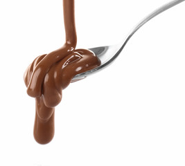 Melted milky brown chocolate pouring from a spoon, isolated on white