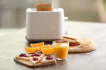 Served table for breakfast with toast and orange juice, on blurred background