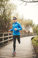 Runner man training on a boardwalk