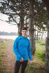 Runner man standing in the middle of a path in nature.