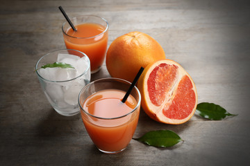 Citrus juice with ice and fresh fruits on wooden background