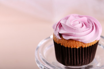 Tasty cupcake on stand, on light background