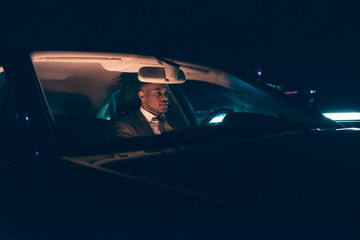 Fototapeta na wymiar Young businessman in car at night.