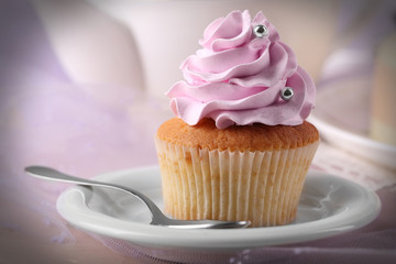 Tasty cupcake on saucer, on light background