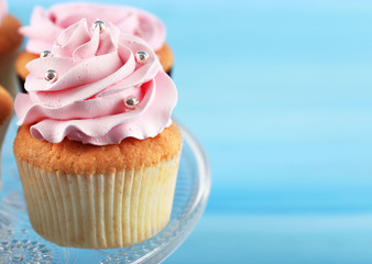 Tasty cupcake on color wooden background