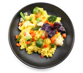 Rice with vegetables on black plate isolated on white