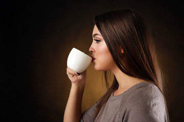 Portrait of pretty woman drinking coffee, close up