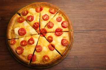 Chopped Margherita pizza on wooden table