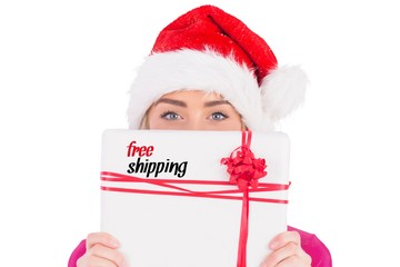 Composite image of festive blonde holding christmas gift