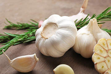 Composition of garlic and rosemary on wooden background, close up