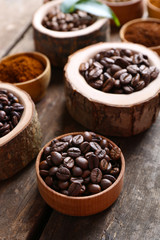Different coffee beans on wooden table, close up
