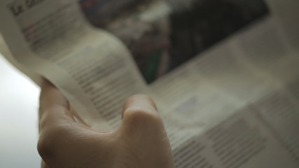 close-up, modern man reading a French newspaper in the morning in his new office - Powered by Adobe