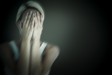 Obraz premium Composite image of sad blonde woman with head on hands 