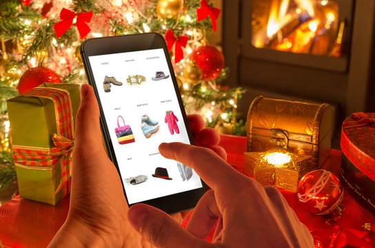 Christmas online shopping with phone. Christmas tree, gifts, lights and decorations. 