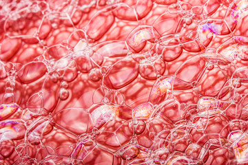 Red background texture of soap bubbles closeup.
