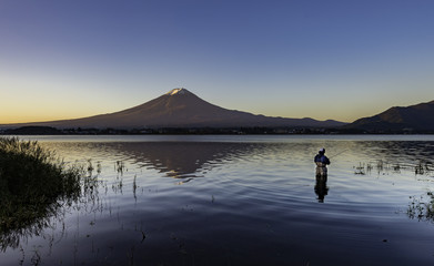 One man fishing in lake kawaguchi with Fuji Mountain background