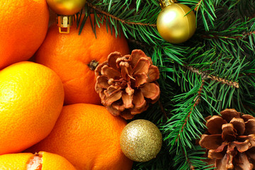 Fototapeta na wymiar tangerines and fir branches cone and Christmas balls closeup