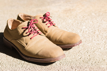 Leather shoes with brush on concrete background
