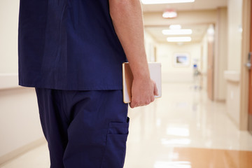 Close Up Of Nurse With Digital Tablet In Hospital Corridor