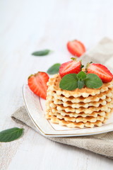 Waffles with strawberries on a wooden table