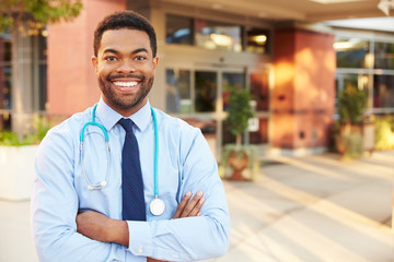 Portrait Of Male Doctor Standing Outside Hospital