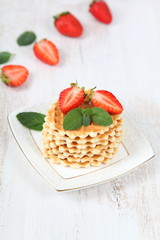 Waffles with strawberries on a wooden table