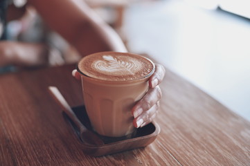 cup of coffee latte on the wood texture   in vintage color tone