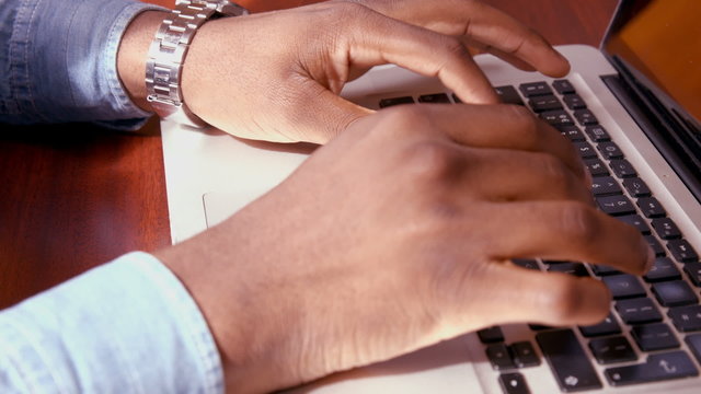 Mans hands using laptop