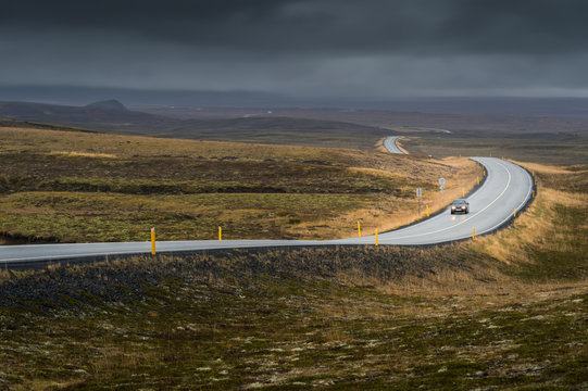 Curve line road with lonely car in Autumn season in cloudy day