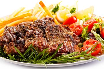 Grilled steak, French fries and vegetables on white background 
